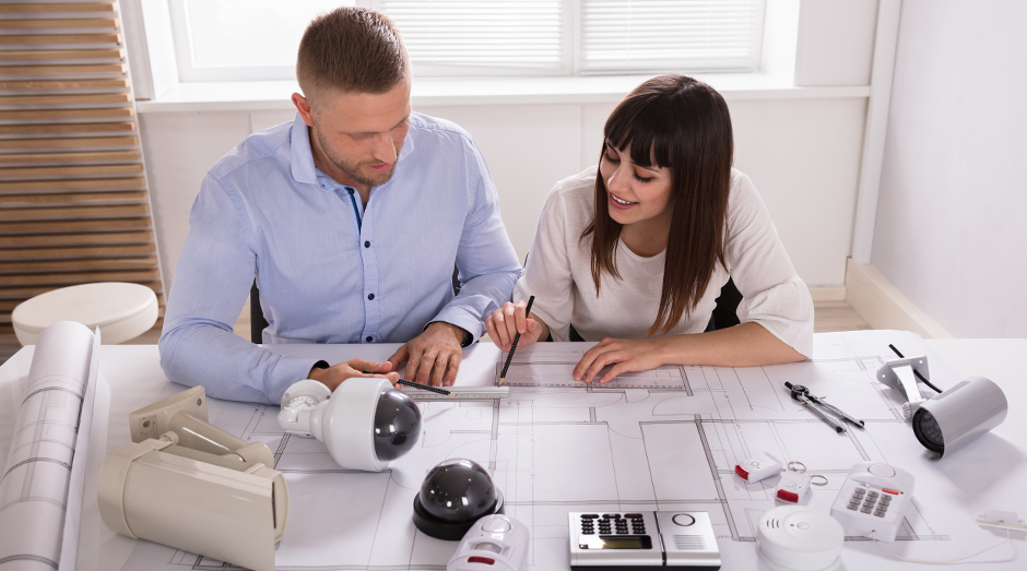 Technician working with business owner to design a custom security system